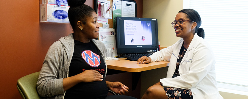 Smiling doctor talking to pregnant patient