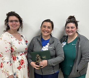 Kimberly Briley posing with team members and award