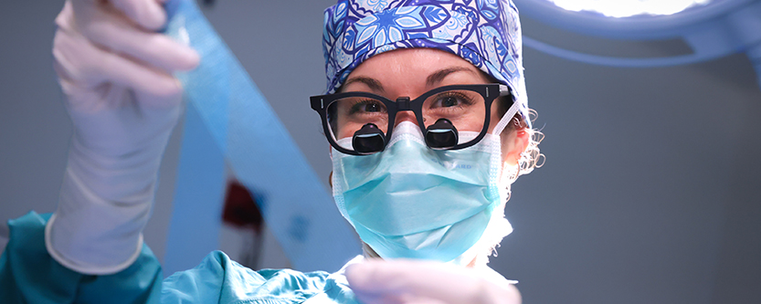 doctor in operating room holding mesh