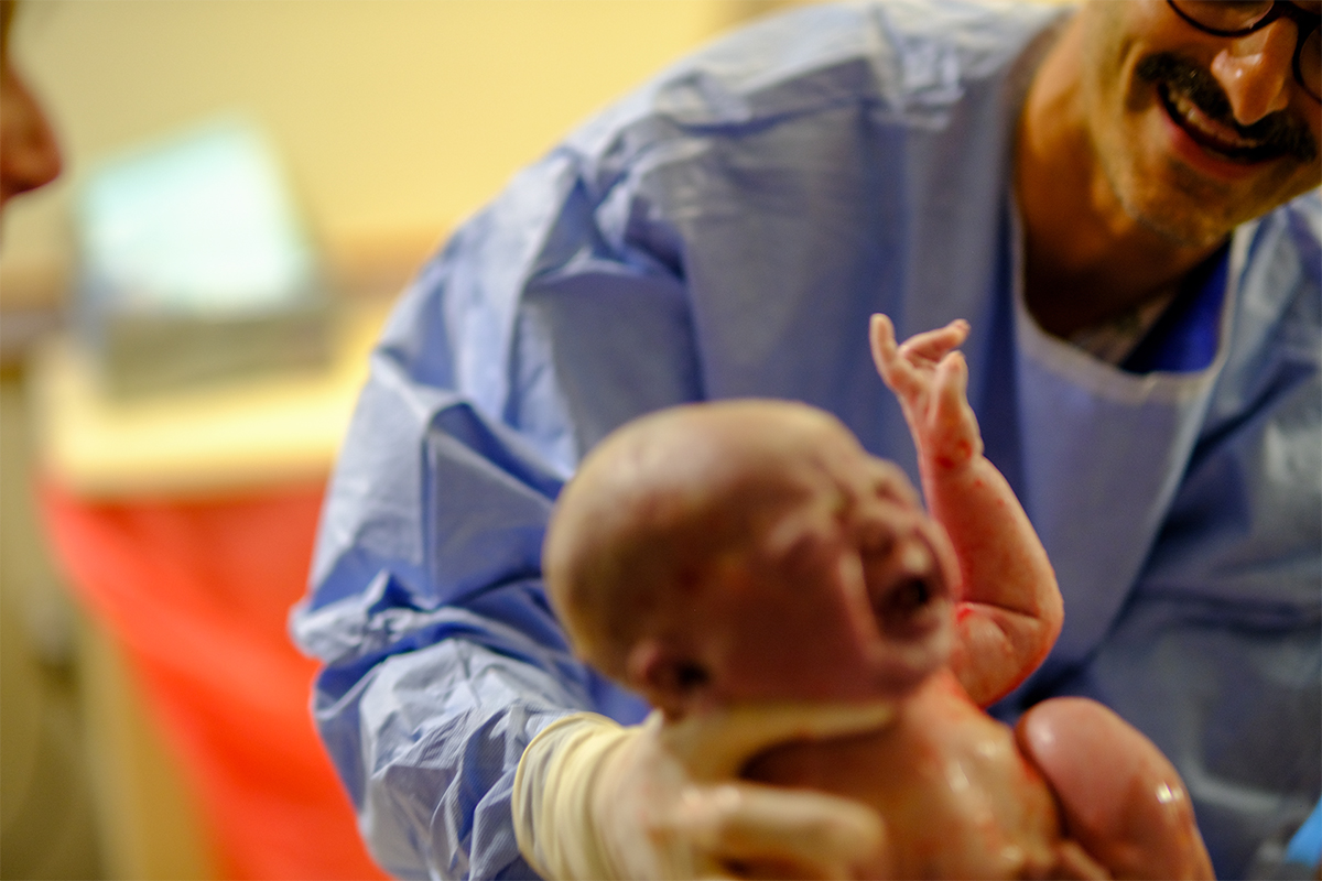 Baby being delivered by doctor.