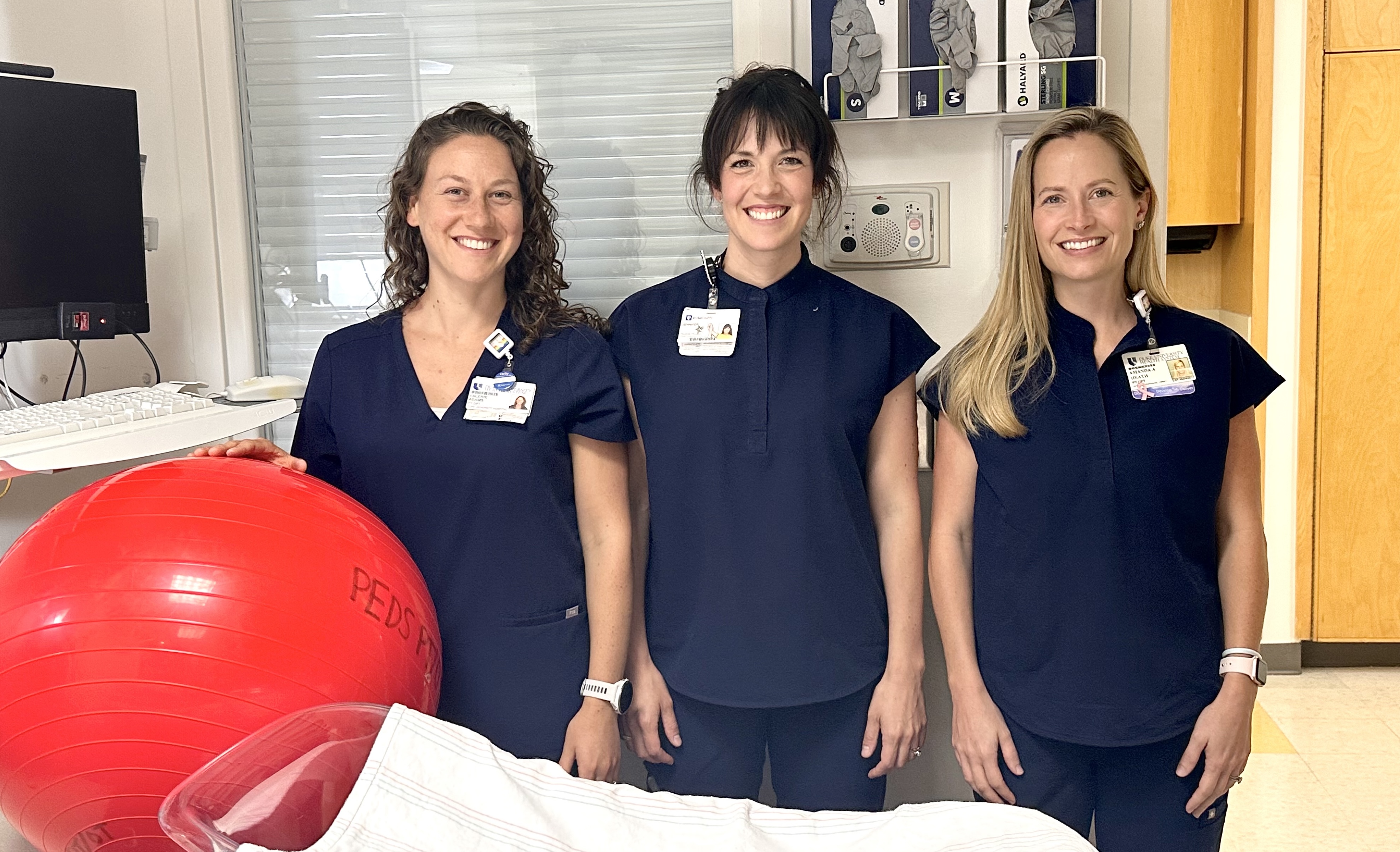 Valerie Adams, PT, DPT, WCS; Jennifer Thornton-Jones, PT, WCS; and Amanda Heath, PT, DPT, WCS, posing with a therapy ball