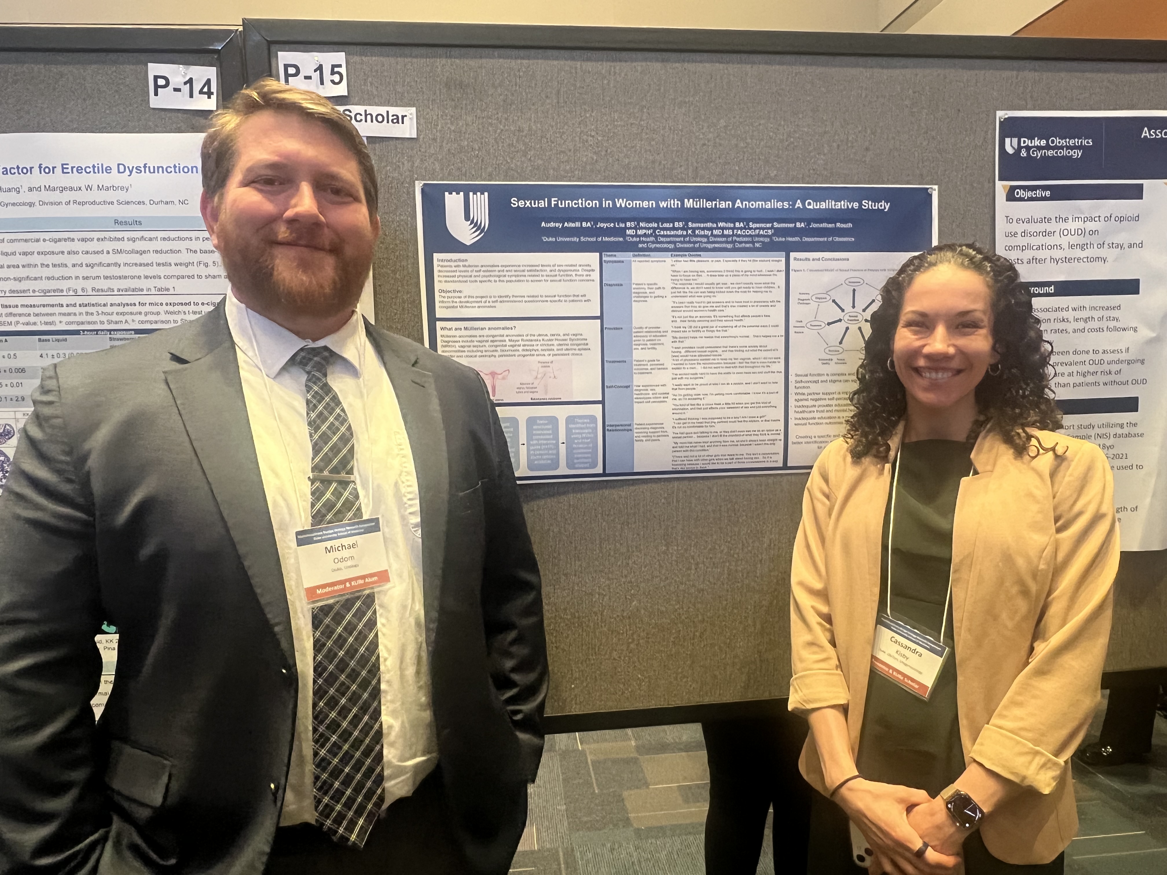 Two people standing in front of research poster.
