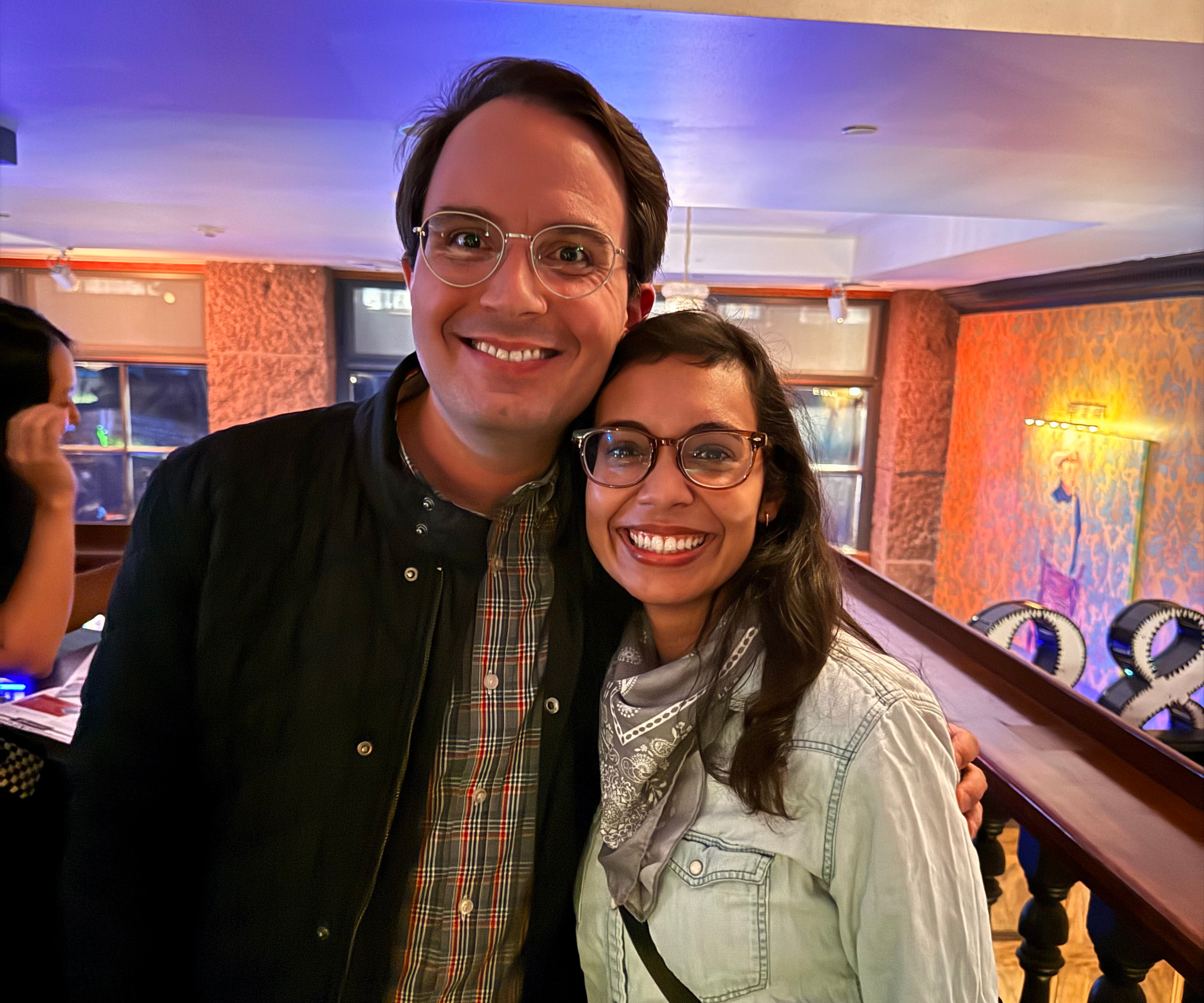Two people in a casual setting smiling. 