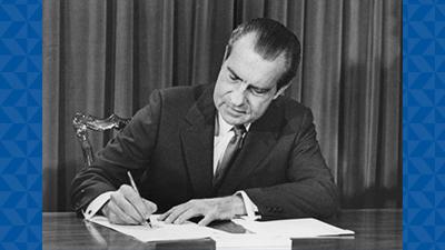 Nixon signing NCI documents.