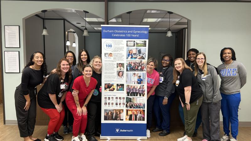 Group of people in front of retractable banner.