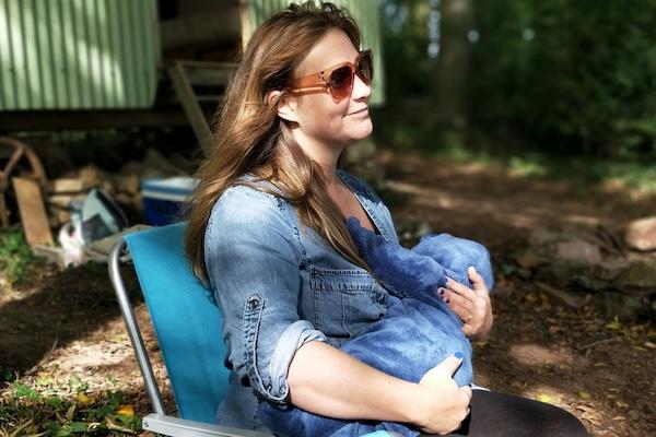 Woman sitting in chair breastfeeding baby