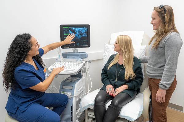 Sonographer with patient and family member.