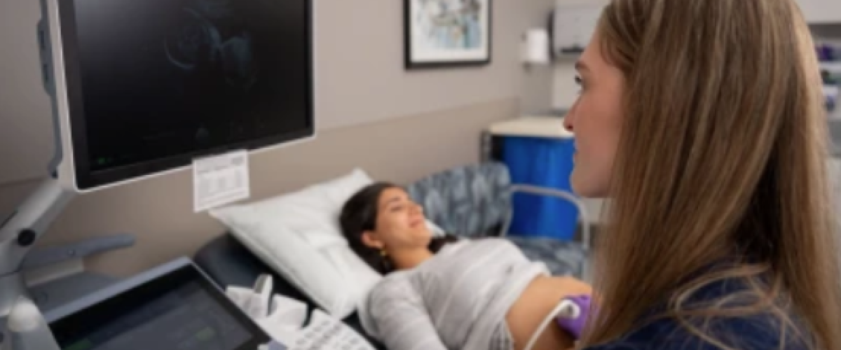 Pregnant woman in exam room having a sonogram.