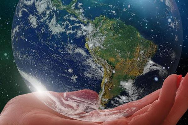 Globe with hand holding it.