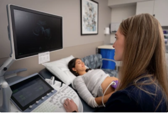 Pregnant woman in exam room having a sonogram.
